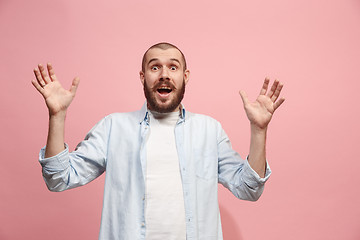 Image showing The young attractive man looking suprised isolated on pink