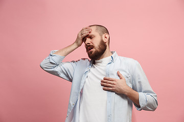 Image showing Man having headache. Isolated over pink background.