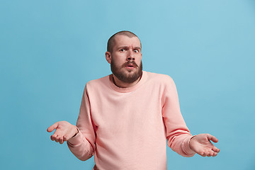 Image showing Beautiful man looking suprised and bewildered isolated on blue