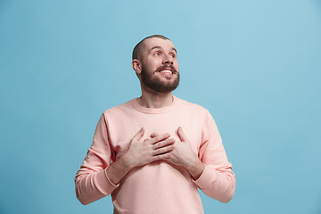 Image showing The happy business man standing and smiling against blue background.