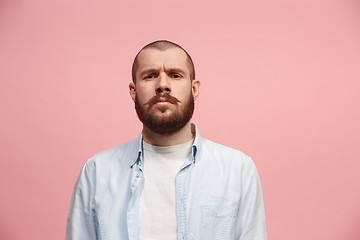 Image showing The serious businessman standing and looking at camera against pink background.