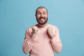 Image showing The happy business man standing and smiling against blue background.