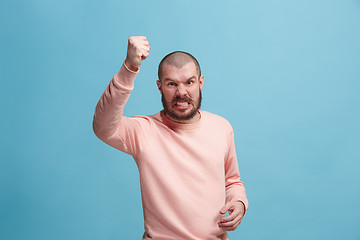 Image showing The young emotional angry man screaming on pink studio background