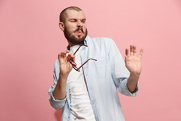 Image showing Let me think. Doubtful pensive man with thoughtful expression making choice against pink background