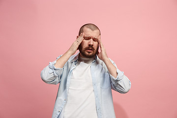 Image showing Man having headache. Isolated over pink background.