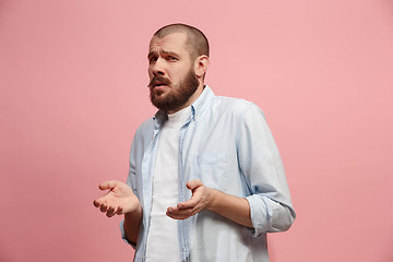 Image showing Let me think. Doubtful pensive man with thoughtful expression making choice against pink background