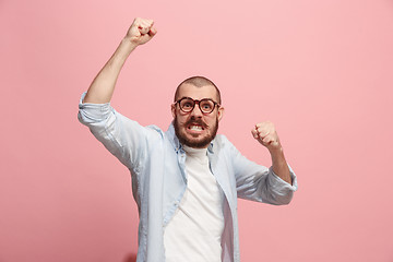 Image showing The young emotional angry man screaming on pink studio background