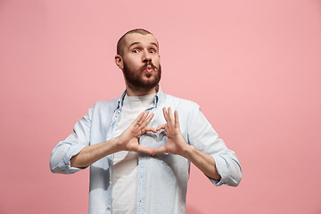 Image showing Portrait of attractive man with kiss isolated over pink background