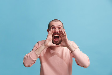 Image showing Isolated on pink young casual man shouting at studio