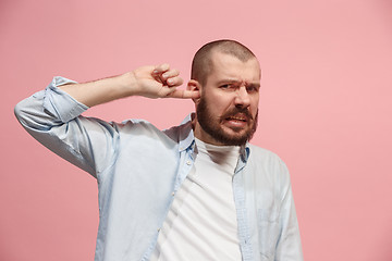 Image showing The Ear ache. The sad man with headache or pain on a pink studio background.