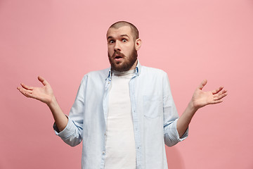 Image showing Let me think. Doubtful pensive man with thoughtful expression making choice against pink background