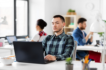 Image showing creative man with laptop working at office