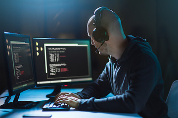 Image showing hacker with coding on laptop computer in dark room