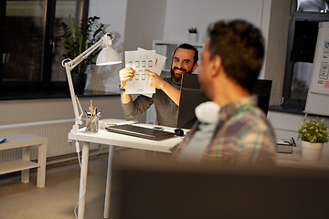 Image showing creative man showing papers to colleague at office