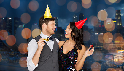 Image showing happy couple with party blowers having fun