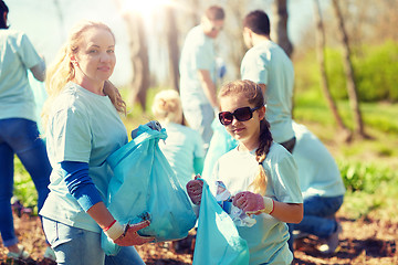 Image showing volunteers with garbage bags cleaning park area