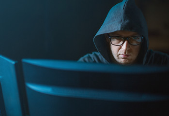 Image showing close up of hacker in hood at computer monitor