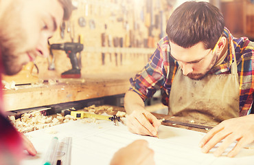 Image showing carpenters with ruler and blueprint at workshop