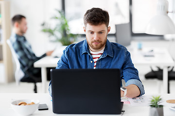 Image showing creative man with laptop working at office