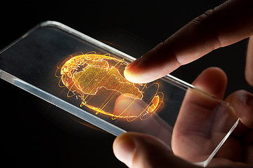 Image showing hands with smartphone and earth hologram