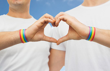 Image showing gay couple with rainbow wristbands and hand heart