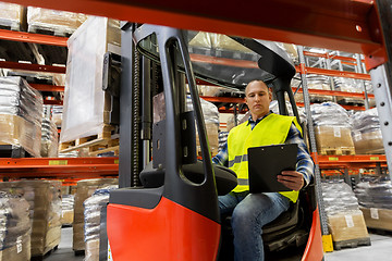 Image showing loader with clipboard in forklift at warehouse