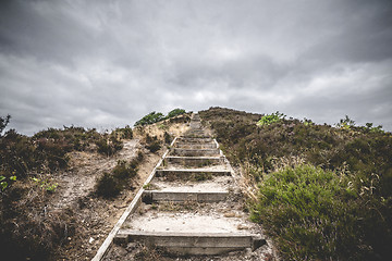 Image showing Wooden stairs going to the top of a hill