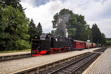 Image showing Old steam locomotive leaving the train station