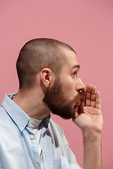 Image showing Isolated on pink young casual man is gossiping at studio