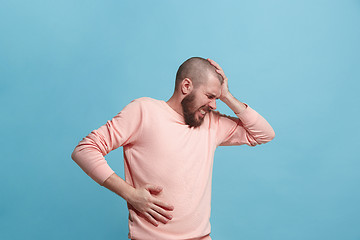 Image showing Young man overwhelmed with a pain in the stomach .