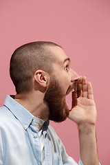 Image showing Isolated on pink young casual man shouting at studio