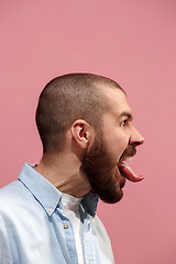 Image showing The young emotional angry, crazy man on pink studio background