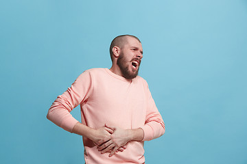 Image showing Young man overwhelmed with a pain in the stomach .