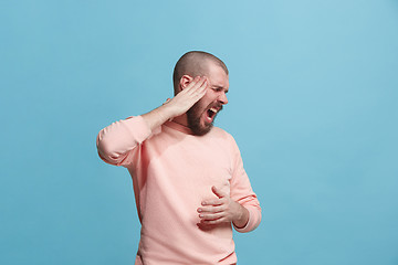 Image showing Man having headache. Isolated over blue background.