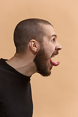 Image showing The young emotional angry, crazy man on pastel studio background