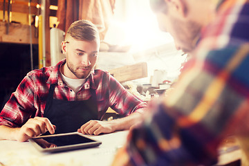 Image showing workmen with tablet pc and blueprint at workshop