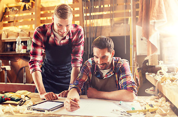 Image showing workmen with tablet pc and blueprint at workshop