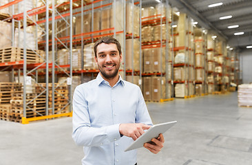 Image showing happy businessman with tablet pc at warehouse