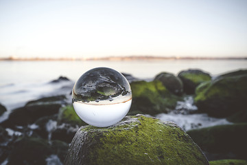 Image showing Crystal ball on moss covered rocks