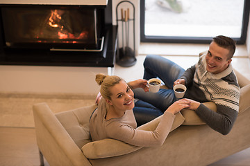 Image showing Young couple  in front of fireplace