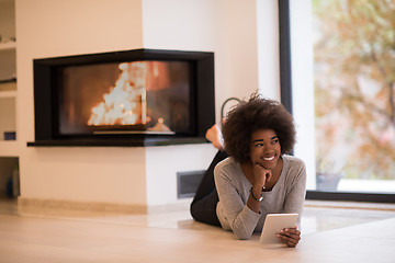 Image showing black women using tablet computer on the floor