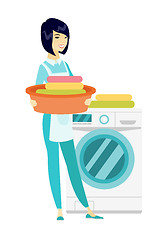 Image showing Housewife using washing machine at laundry.