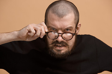 Image showing The young emotional angry man on pastel studio background