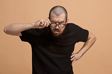 Image showing The young emotional angry man on pastel studio background