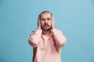 Image showing Young man covering his ears and shouting.