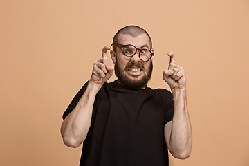 Image showing The young emotional angry man on pastel studio background