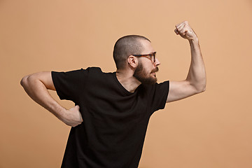 Image showing The young emotional angry man on pastel studio background