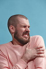 Image showing Young man overwhelmed with a pain in the shoulder.