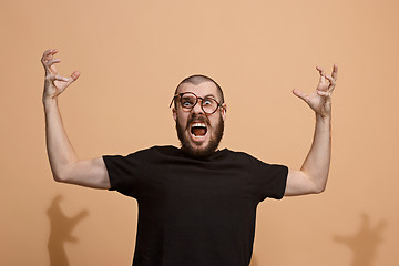 Image showing The young emotional angry man on pastel studio background