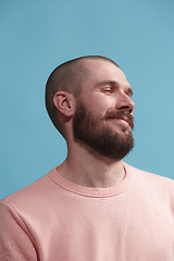 Image showing Isolated on blue young casual man smiling and enjoying at studio